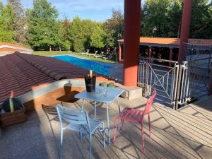 eine Terrasse mit einem Tisch und Stühlen neben einem Pool in der Unterkunft Ex Villa Gastaldi in Asti