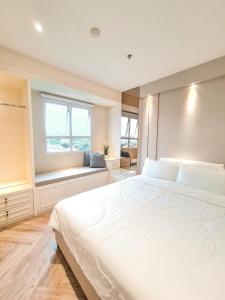 Un dormitorio con una gran cama blanca y una ventana en R30 Apartemen Gateway Pasteur 2BR Daymentroom en Bandung