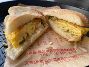 een sandwich wordt op een bord doormidden gesneden bij 自在緣精品民宿 in Magong