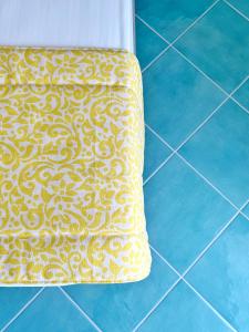 a yellow and white pillow sitting on a tiled floor at Casa Adelaide in Capri