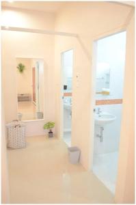 La salle de bains blanche est pourvue d'un lavabo et d'un miroir. dans l'établissement 100sqm 2 bed apartment Sukhothai City, à Sukhothaï