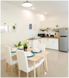 a kitchen with a table and chairs and a kitchen with a refrigerator at 2 bedroom apartment in Sukhothai