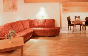 a living room with a red couch and a table at Lovely Apartment In St, Gallenkirch With Kitchen in Aussersiggam