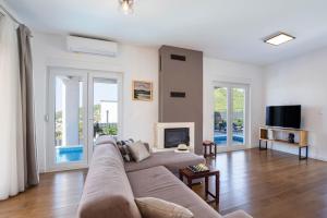 a living room with a couch and a tv at Villa Dorso with heated pool in Klis
