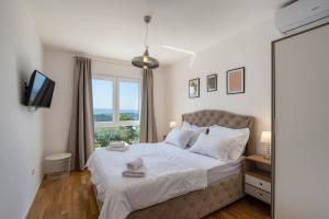 a bedroom with a large bed with a window at Villa Dorso with heated pool in Klis +51 photos