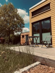 a patio with two chairs and a table on a house at TINYLODGE am Ellertshäuser See in Stadtlauringen