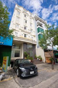 ein schwarzes Auto, das vor einem Gebäude parkt in der Unterkunft Hoang Anh Star Hotel in Ho-Chi-Minh-Stadt