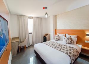 une chambre d'hôtel avec un lit et une télévision dans l'établissement Hotel SunSet Beni Mellal, à Béni Mellal