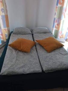 Una cama con dos almohadas encima. en Elo Apartman, en Csokonyavisonta