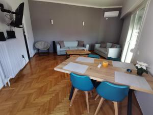 sala de estar con mesa de madera y sillas azules en Penthouse spacious w super wifi & terrace, 2 min from metro en Atenas