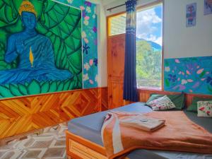 a bedroom with a mural of a buddha on the wall at Highland Gojh Kasol in Kasol