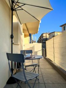 een tafel en stoelen op een balkon met een parasol bij Subalterno 33 in La Spezia