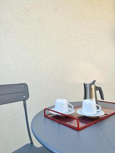 een dienblad met twee kopjes en een waterkoker op een tafel bij Subalterno 33 in La Spezia