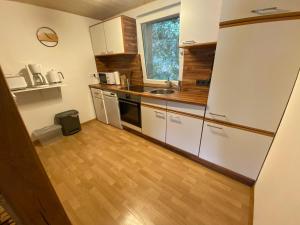 cocina con electrodomésticos blancos y suelo de madera en Schmallenberger Ferienhaus, en Schmallenberg
