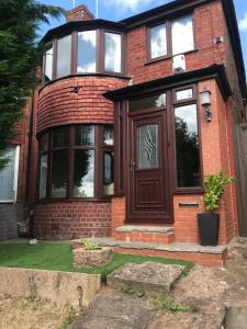 a red brick house with a brown door at 3 bedroom home with stunning views and hot tub in Birmingham