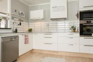 una cocina blanca con armarios y electrodomésticos blancos en RIBO Apartment Arctic en Kiruna