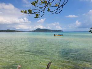 a boat in the water on a beach at Mangrove Beach Bungalows in Koh Rong Sanloem