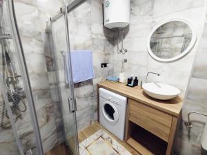 a bathroom with a washing machine and a sink at Spacious and Modern Apartment in Town Center in Konjic