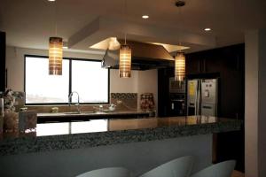 a kitchen with a counter with a sink and a refrigerator at Espectacular casa grande vacacional en Manta! in Manta