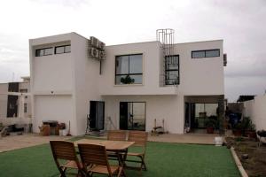 Casa blanca grande con mesa y sillas en Espectacular casa grande vacacional en Manta!, en Manta