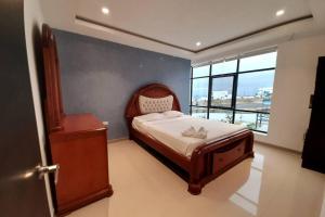 um pequeno quarto com uma cama e uma janela em Espectacular casa grande vacacional en Manta! em Manta