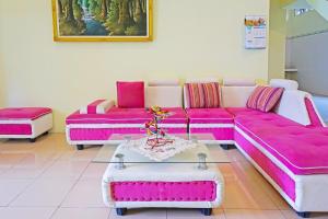 a living room with pink couches and a table at Super OYO 91568 Trisna Srabah Resort Homestay & Resto in Kalangbret