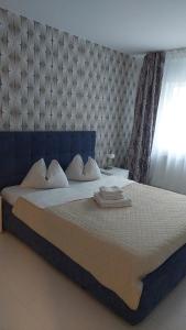 a bedroom with a large bed with a blue headboard at Lexy's Apartment in Braşov