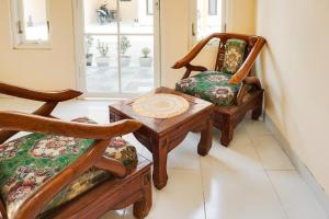 een woonkamer met 2 stoelen en een tafel bij OYO Life 91569 Omah Wijaya Kusuma Syariah in Malang