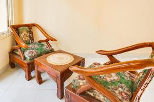 a living room with two chairs and a table at OYO Life 91569 Omah Wijaya Kusuma Syariah in Malang