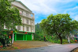 un edificio con un garage verde accanto a un albero di OYO LIfe 91571 Hotel Ss Bukit Cemara Syariah a Batu