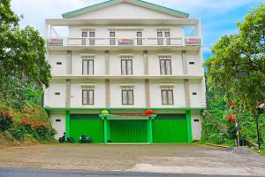 una grande casa con un garage verde davanti di OYO LIfe 91571 Hotel Ss Bukit Cemara Syariah a Batu