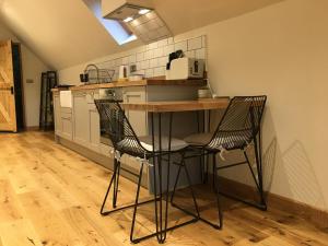 cocina con mesa y 2 sillas en The Hive - beautiful studio with amazing hot tub en Cratfield