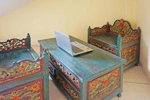 a laptop computer sitting on a desk with two beds at OYO 91580 Kost Bougenville Syariah in Madiun