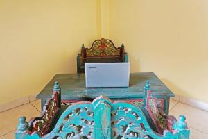a wooden table with a laptop on top of it at OYO 91580 Kost Bougenville Syariah in Madiun