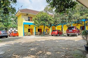 a yellow building with cars parked in front of it at OYO 91573 Hotel Family Blitar in Blitar