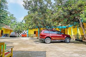a red suv parked in front of a yellow building at OYO 91573 Hotel Family Blitar in Blitar