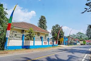 a street with a blue fence and a building at OYO 91573 Hotel Family Blitar in Blitar