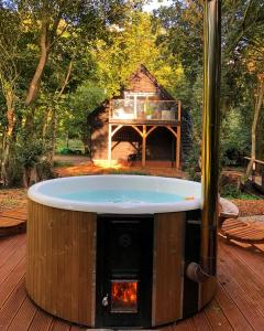 eine Feuerstelle in der Mitte einer Holzterrasse in der Unterkunft The Hive - beautiful studio with amazing hot tub in Cratfield