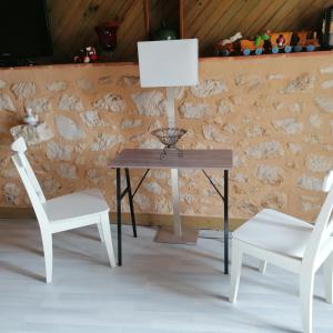 - une table avec deux chaises et une lampe dans l'établissement Le Marronnier, à Saint-Vincent-de-Pertignas