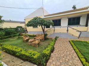 a patio with tables and chairs in front of a house at J Nova LDA in São Tomé