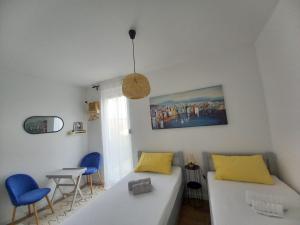 a living room with a white couch and blue chairs at Villa apartment Laganini in Okrug Gornji