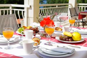 a table with plates of food and glasses of orange juice at Boutique Hotel Villa Telenta in Vela Luka