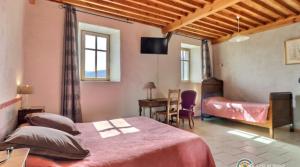 a bedroom with two beds and a desk and a table at Domaine du Clap in Pranles