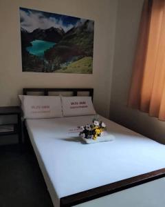Una cama blanca con flores encima. en WJV INN CASUNTINGAN, en Mandaue