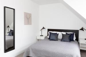 een witte slaapkamer met een bed en een spiegel bij Hampden Apartments - The William in Eton