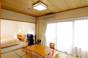 a bedroom with a bed and a table in a room at Hakone Forest of Verde in Hakone