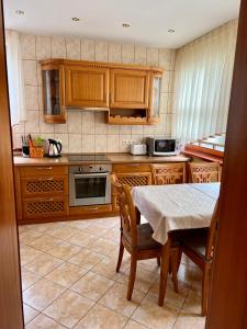 eine Küche mit Holzschränken und einem Tisch mit Stühlen in der Unterkunft Gedimino Apartamentai in Juodkrantė