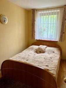 a small bedroom with a bed with a window at Gedimino Apartamentai in Juodkrantė