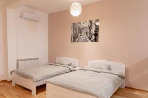 a bedroom with two beds and a painting on the wall at AirMi hotel in Surčin