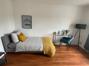 - une chambre avec un lit doté d'une couverture jaune et d'une chaise dans l'établissement Modern 4 Zi Rooms Netflix, Wifi, Parken CasaLuna85, à Flöha